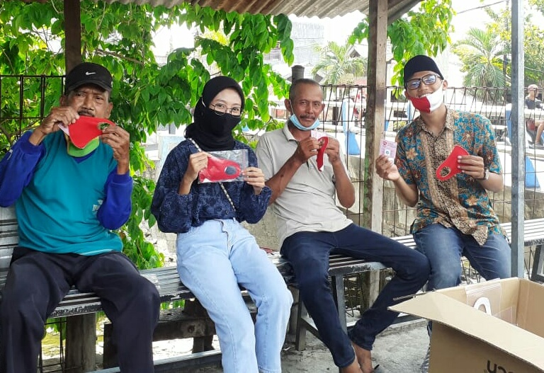 Komunitas Lamongan Creative hub menggelar aksi solidaritas dengan membagikan masker kepada pengguna ...